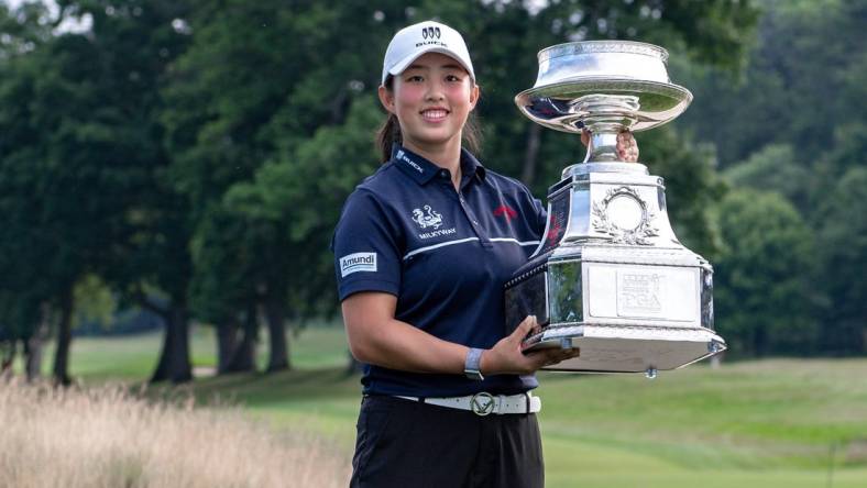 Jun 25, 2023; Springfield, New Jersey, USA; Ruoning Yin raises the championship trophy after winning the KPMG Women's PGA Championship golf tournament. Mandatory Credit: John Jones-USA TODAY Sports