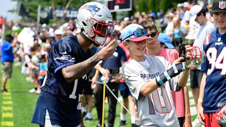 Jul 26, 2023; Foxborough, MA, USA; New England Patriots cornerback Jack Jones (13) takes a selfie with a fan during training camp at Gillette Stadium. Mandatory Credit: Eric Canha-USA TODAY Sports