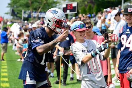 Jul 26, 2023; Foxborough, MA, USA; New England Patriots cornerback Jack Jones (13) takes a selfie with a fan during training camp at Gillette Stadium. Mandatory Credit: Eric Canha-USA TODAY Sports