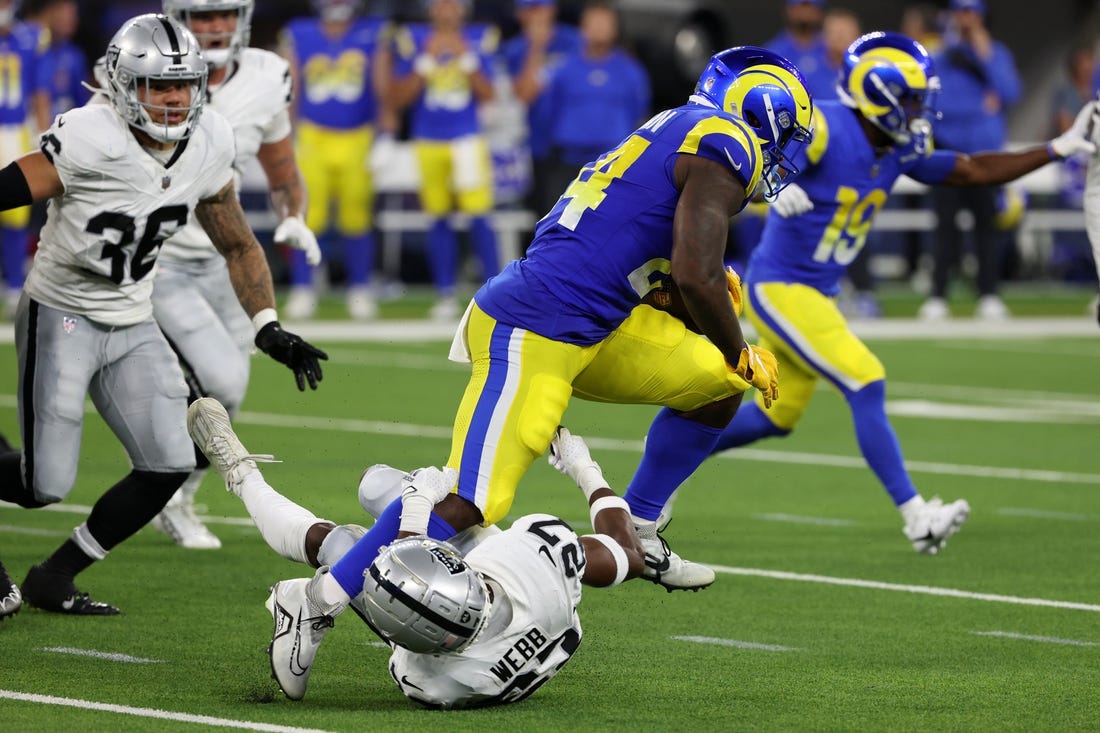 Aug 19, 2023; Inglewood, California, USA;  Los Angeles Rams running back Royce Freeman (24) runs over Las Vegas Raiders cornerback Sam Webb (27) during the third quarter at SoFi Stadium. Mandatory Credit: Kiyoshi Mio-USA TODAY Sports