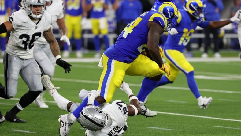 Aug 19, 2023; Inglewood, California, USA;  Los Angeles Rams running back Royce Freeman (24) runs over Las Vegas Raiders cornerback Sam Webb (27) during the third quarter at SoFi Stadium. Mandatory Credit: Kiyoshi Mio-USA TODAY Sports