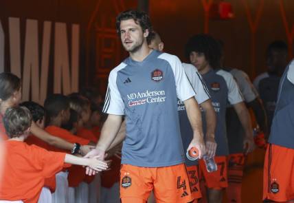 Aug 30, 2023; Houston, Texas, USA; Houston Dynamo FC defender Ethan Bartlow (4) and Dynamo FC players greet children in the tunnel before the match against the Columbus Crew SC at Shell Energy Stadium. Mandatory Credit: Troy Taormina-USA TODAY Sports