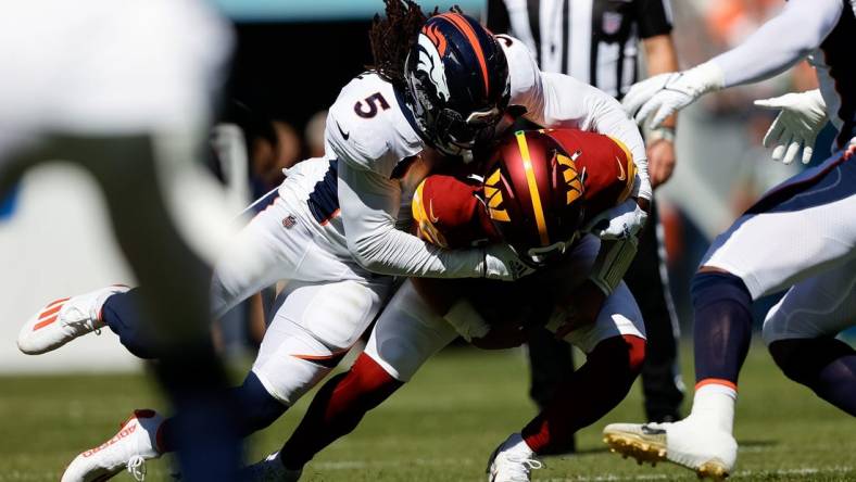 Sep 17, 2023; Denver, Colorado, USA; Washington Commanders quarterback Sam Howell (14) is sacked by Denver Broncos linebacker Randy Gregory (5) in the first quarter at Empower Field at Mile High. Mandatory Credit: Isaiah J. Downing-USA TODAY Sports