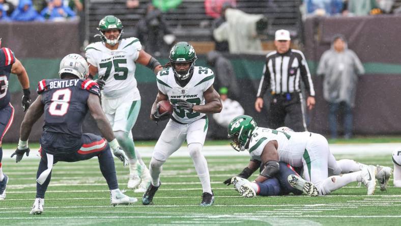 Sep 24, 2023; East Rutherford, New Jersey, USA; New York Jets running back Dalvin Cook (33) carries the ball asNew England Patriots linebacker Ja'Whaun Bentley (8) defends during the second half at MetLife Stadium. Mandatory Credit: Vincent Carchietta-USA TODAY Sports