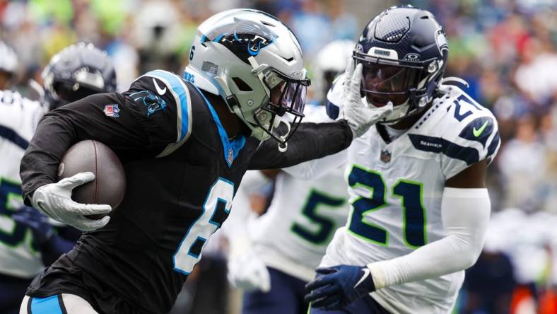 Sep 24, 2023; Seattle, Washington, USA; Carolina Panthers running back Miles Sanders (6) stiff-arms away from a tackle attempt by Seattle Seahawks cornerback Devon Witherspoon (21) during the second quarter at Lumen Field. Mandatory Credit: Joe Nicholson-USA TODAY Sports