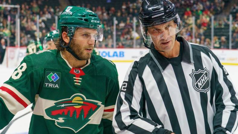 Sep 28, 2023; Saint Paul, Minnesota, USA; Minnesota Wild right wing Ryan Hartman (38) and referee Chris Lee (82) chat during a break in action against the Colorado Avalanche in the third period at Xcel Energy Center. Mandatory Credit: Matt Blewett-USA TODAY Sports