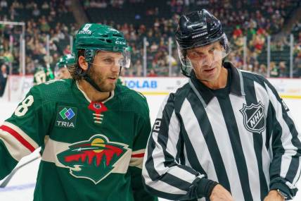 Sep 28, 2023; Saint Paul, Minnesota, USA; Minnesota Wild right wing Ryan Hartman (38) and referee Chris Lee (82) chat during a break in action against the Colorado Avalanche in the third period at Xcel Energy Center. Mandatory Credit: Matt Blewett-USA TODAY Sports
