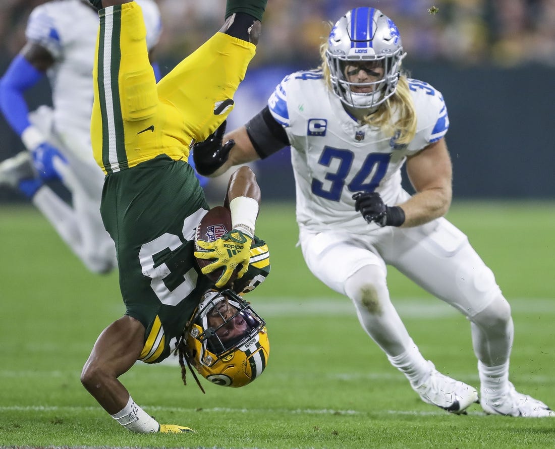 Sep 28, 2023; Green Bay, Wisconsin, USA; Green Bay Packers running back Aaron Jones (33) is upended against the Detroit Lions during their football game on Thursday, September 28, 2023, at Lambeau Field in Green Bay, Wis. Mandatory Credit: Tork Mason-USA TODAY Sports