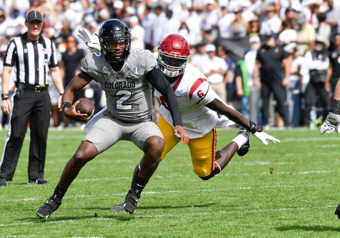 Sep 30, 2023; Boulder, Colorado, USA; Colorado Buffaloes quarterback Shedeur Sanders (2) attempts to scramble from USC Trojans defensive lineman Anthony Lucas (6) during the fourth quarter at Folsom Field. Mandatory Credit: John Leyba-USA TODAY Sports