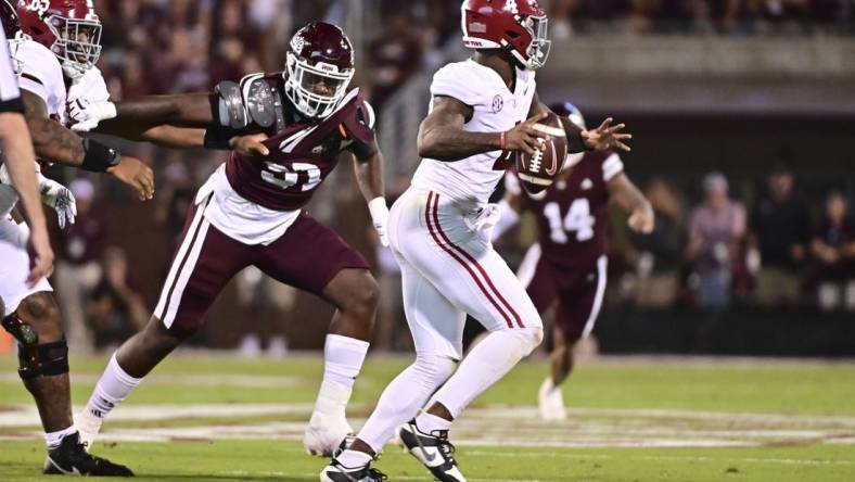 Sep 30, 2023; Starkville, Mississippi, USA; Alabama Crimson Tide quarterback Jalen Milroe (4) moves in the pocket while defended by Mississippi State Bulldogs defensive end Deonte Anderson (91) during the second quarter at Davis Wade Stadium at Scott Field. Mandatory Credit: Matt Bush-USA TODAY Sports