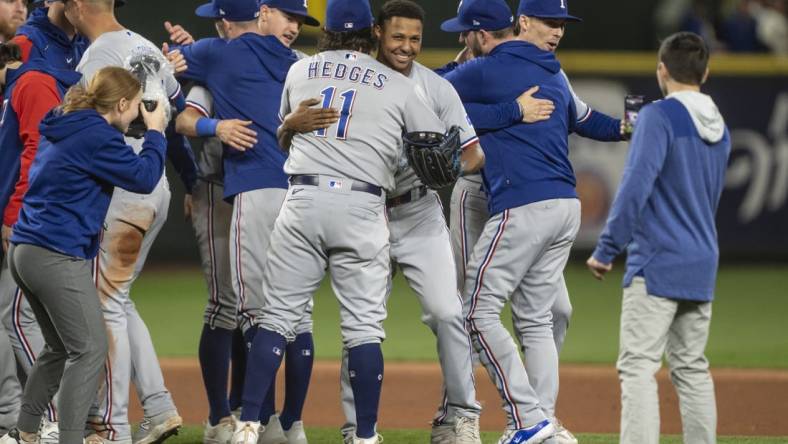 Sep 30, 2023; Seattle, Washington, USA; Texas Rangers relief pitcher Jose Leclerc (25), fourth from right, hugs catcher Austin Hedges (11) after a game against the Seattle Mariners at T-Mobile Park. Mandatory Credit: Stephen Brashear-USA TODAY Sports