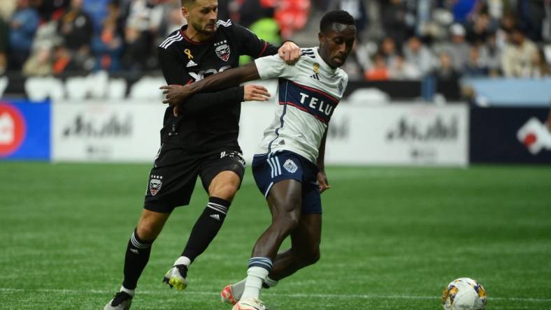 Sep 30, 2023; Vancouver, British Columbia, CAN;  D.C. United midfielder Mateusz Klich (43) battles for the ball against Vancouver Whitecaps FC forward Richie Laryea (7) during the first half at BC Place. Mandatory Credit: Anne-Marie Sorvin-USA TODAY Sports