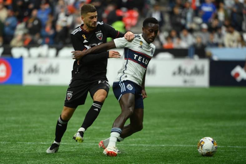 Sep 30, 2023; Vancouver, British Columbia, CAN;  D.C. United midfielder Mateusz Klich (43) battles for the ball against Vancouver Whitecaps FC forward Richie Laryea (7) during the first half at BC Place. Mandatory Credit: Anne-Marie Sorvin-USA TODAY Sports