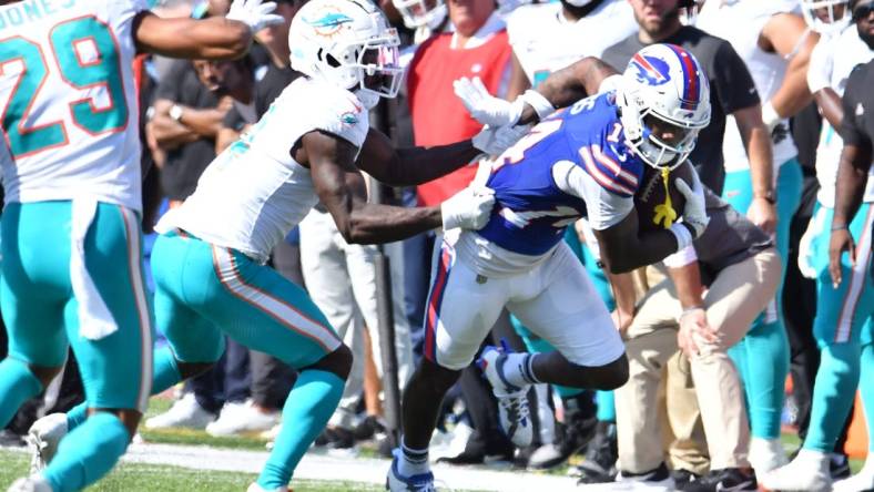 Oct 1, 2023; Orchard Park, New York, USA; Buffalo Bills wide receiver Stefon Diggs (14) breaks a tackle by Miami Dolphins cornerback Kader Kohou (4) to score a touchdown  in the second quarter at Highmark Stadium. Mandatory Credit: Mark Konezny-USA TODAY Sports