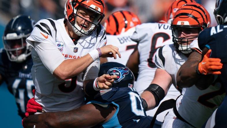Cincinnati Bengals quarterback Joe Burrow (9) takes a hit by Tennessee Titans defensive tackle Teair Tart (93) in the fourth quarter at Nissan Stadium in Nashville, Tenn., Sunday, Oct. 1, 2023.