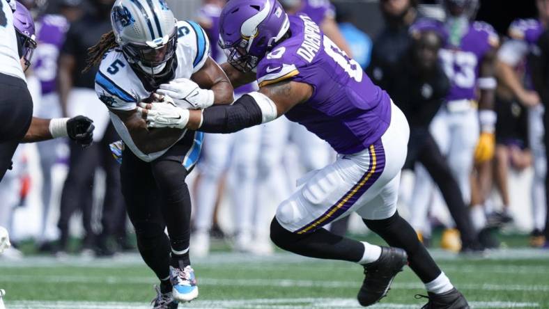 Oct 1, 2023; Charlotte, North Carolina, USA; Carolina Panthers place kicker Eddy Pineiro (4) is tackled by Minnesota Vikings linebacker Marcus Davenport (0) during the second half at Bank of America Stadium. Mandatory Credit: Jim Dedmon-USA TODAY Sports