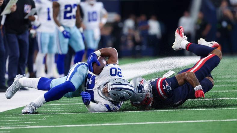 Oct 1, 2023; Arlington, Texas, USA;  Dallas Cowboys running back Tony Pollard (20) is tackled by New England Patriots cornerback Christian Gonzalez (6) during the first quarter at AT&T Stadium. Mandatory Credit: Kevin Jairaj-USA TODAY Sports