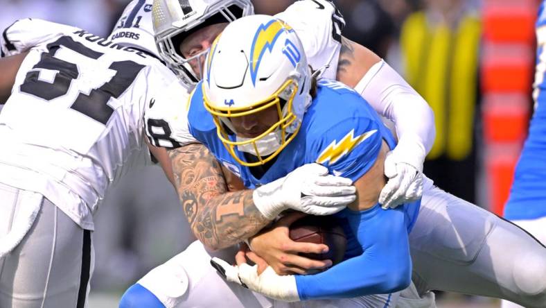 Oct 1, 2023; Inglewood, California, USA;  Los Angeles Chargers quarterback Justin Herbert (10) is sacked by Las Vegas Raiders defensive end Maxx Crosby (98) in the fourth quarter at SoFi Stadium. Mandatory Credit: Jayne Kamin-Oncea-USA TODAY Sports