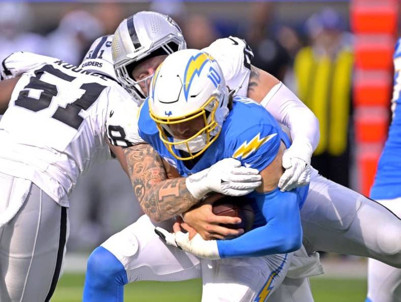 Oct 1, 2023; Inglewood, California, USA;  Los Angeles Chargers quarterback Justin Herbert (10) is sacked by Las Vegas Raiders defensive end Maxx Crosby (98) in the fourth quarter at SoFi Stadium. Mandatory Credit: Jayne Kamin-Oncea-USA TODAY Sports