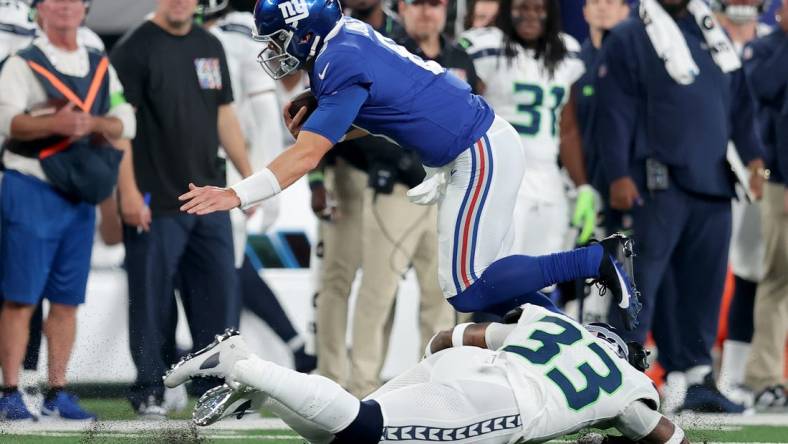 Oct 2, 2023; East Rutherford, New Jersey, USA; New York Giants quarterback Daniel Jones (8) runs with the ball against Seattle Seahawks safety Jamal Adams (33) during the first quarter at MetLife Stadium. Mandatory Credit: Brad Penner-USA TODAY Sports