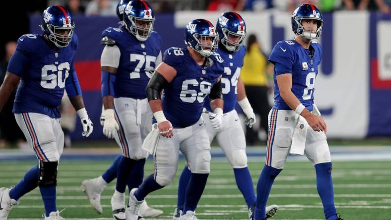 Oct 2, 2023; East Rutherford, New Jersey, USA; New York Giants quarterback Daniel Jones (8) walks off the field with guards Marcus McKethan (60) and Joshua Ezeudu (75) and Ben Bredeson (68) and Mark Glowinski (64) after being sacked during the fourth quarter against the Seattle Seahawks at MetLife Stadium. Mandatory Credit: Brad Penner-USA TODAY Sports