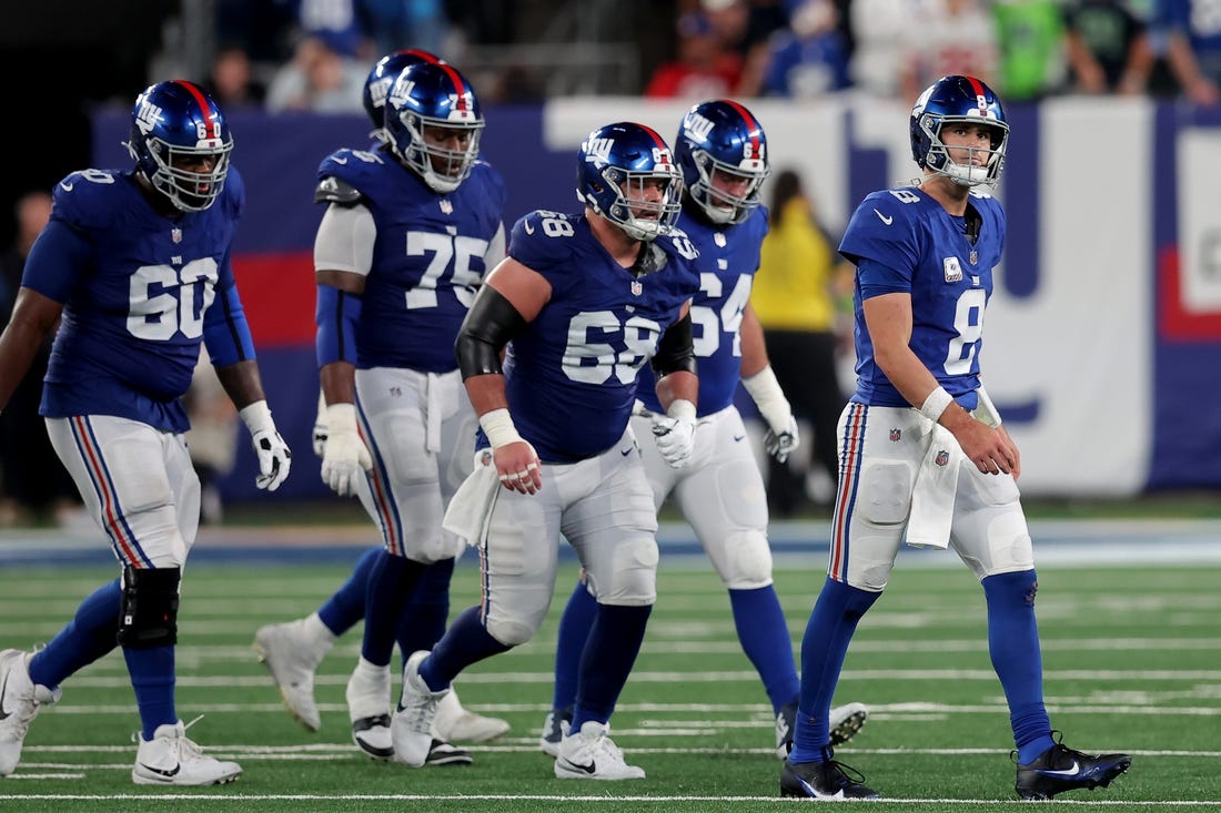 Oct 2, 2023; East Rutherford, New Jersey, USA; New York Giants quarterback Daniel Jones (8) walks off the field with guards Marcus McKethan (60) and Joshua Ezeudu (75) and Ben Bredeson (68) and Mark Glowinski (64) after being sacked during the fourth quarter against the Seattle Seahawks at MetLife Stadium. Mandatory Credit: Brad Penner-USA TODAY Sports