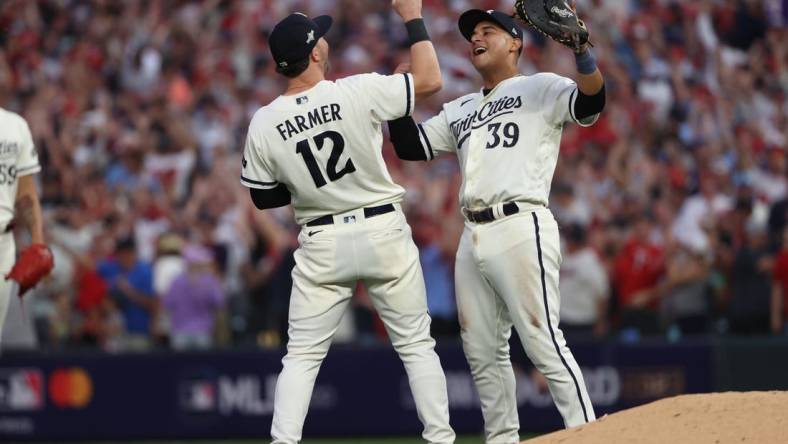 Oct 3, 2023; Minneapolis, Minnesota, USA; Minnesota Twins third baseman Kyle Farmer (12) and first baseman Donovan Solano (39) celebrated after defeating Toronto Blue Jays  during game one of the Wildcard series for the 2023 MLB playoffs at Target Field. Mandatory Credit: Jesse Johnson-USA TODAY Sports