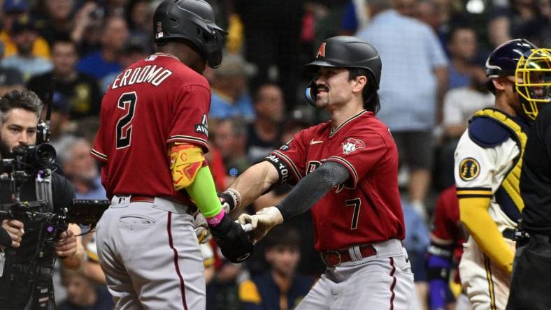 Oct 3, 2023; Milwaukee, Wisconsin, USA; Arizona Diamondbacks shortstop Geraldo Perdomo (2) and left fielder Corbin Carroll (7) celebrate scoring in the third inning against the Milwaukee Brewers during game one of the Wildcard series for the 2023 MLB playoffs at American Family Field. Mandatory Credit: Michael McLoone-USA TODAY Sports