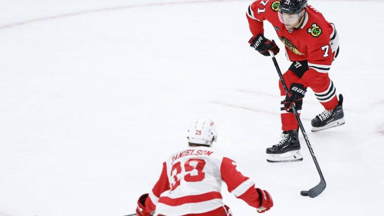 Oct 3, 2023; Chicago, Illinois, USA; Chicago Blackhawks forward Taylor Hall (71) passes the puck against Detroit Red Wings forward Nate Danielson (29) during the third period of a preseason hockey game at United Center. Mandatory Credit: Kamil Krzaczynski-USA TODAY Sports