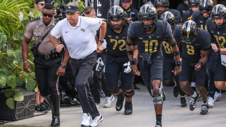 Sep 30, 2023; Orlando, Florida, USA; UCF Knights head coach Gus Malzahn and team run onto the field before the game against the Baylor Bears at FBC Mortgage Stadium. Mandatory Credit: Mike Watters-USA TODAY Sports