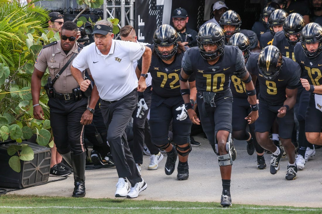 Sep 30, 2023; Orlando, Florida, USA; UCF Knights head coach Gus Malzahn and team run onto the field before the game against the Baylor Bears at FBC Mortgage Stadium. Mandatory Credit: Mike Watters-USA TODAY Sports