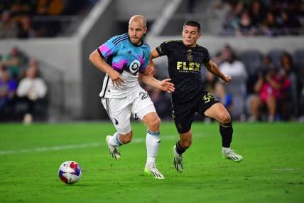 Oct 4, 2023; Los Angeles, California, USA; Los Angeles FC defender Sergi Palencia (30) plays for the ball against Minnesota United forward Teemu Pukki (22) during the first half at BMO Stadium. Mandatory Credit: Gary A. Vasquez-USA TODAY Sports