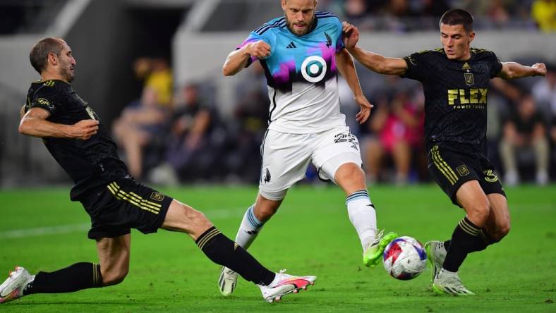 Oct 4, 2023; Los Angeles, California, USA; Los Angeles FC defender Sergi Palencia (30) and defender Giorgio Chiellini (14) play for the ball against Minnesota United forward Teemu Pukki (22) during the first half at BMO Stadium. Mandatory Credit: Gary A. Vasquez-USA TODAY Sports