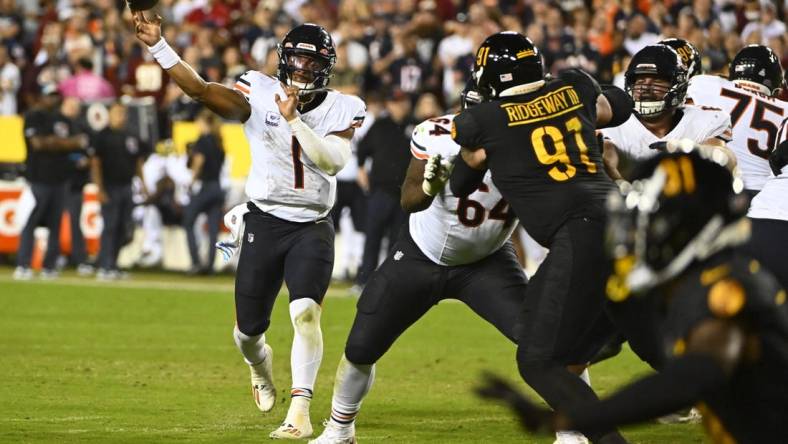 Oct 5, 2023; Landover, Maryland, USA; Chicago Bears quarterback Justin Fields (1) passes the ball as Washington Commanders defensive tackle John Ridgeway (91) defends during the first half at FedExField. Mandatory Credit: Brad Mills-USA TODAY Sports