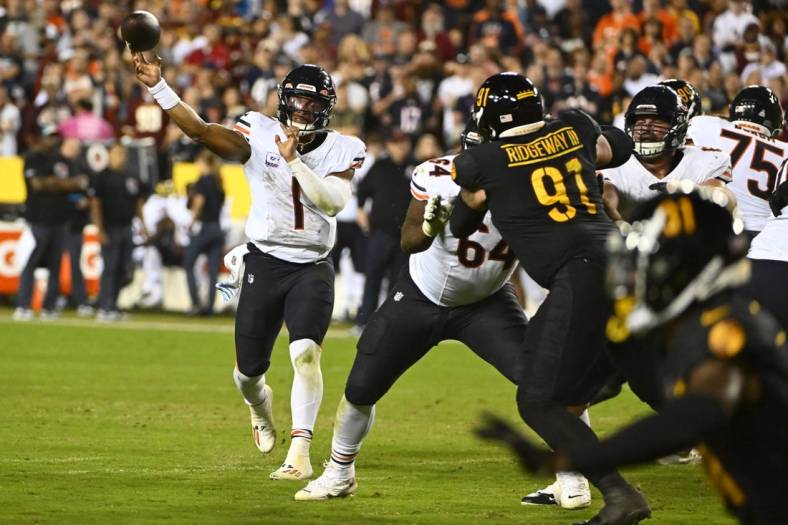 Oct 5, 2023; Landover, Maryland, USA; Chicago Bears quarterback Justin Fields (1) passes the ball as Washington Commanders defensive tackle John Ridgeway (91) defends during the first half at FedExField. Mandatory Credit: Brad Mills-USA TODAY Sports