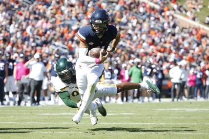 Oct 7, 2023; Charlottesville, Virginia, USA; Virginia Cavaliers quarterback Tony Muskett (11) scores a touchdown past William & Mary Tribe defensive lineman Nate Lynn (99) during the first half at Scott Stadium. Mandatory Credit: Amber Searls-USA TODAY Sports