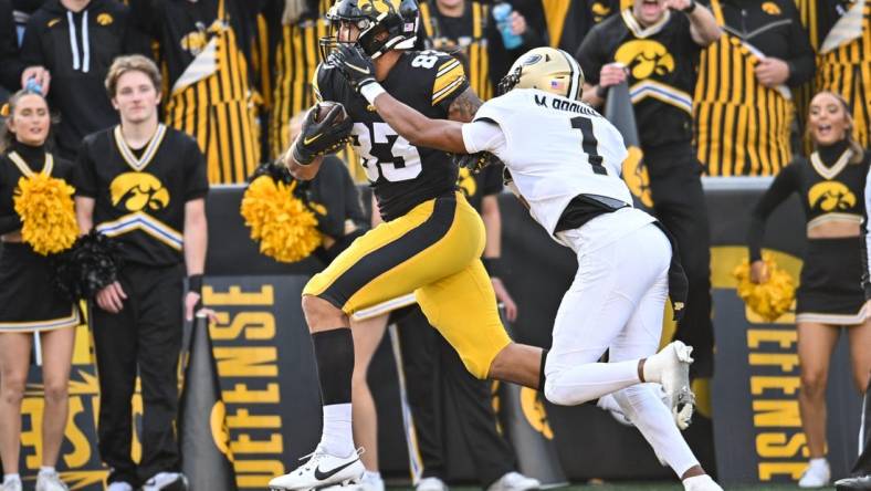 Oct 7, 2023; Iowa City, Iowa, USA; Iowa Hawkeyes tight end Erick All (83) catches a touchdown pass from quarterback Deacon Hill (not pictured) as Purdue Boilermakers Markevious Brown (1) defends during the fourth quarter at Kinnick Stadium. Mandatory Credit: Jeffrey Becker-USA TODAY Sports