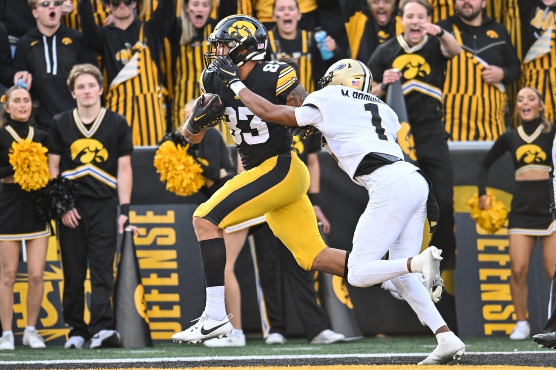 Oct 7, 2023; Iowa City, Iowa, USA; Iowa Hawkeyes tight end Erick All (83) catches a touchdown pass from quarterback Deacon Hill (not pictured) as Purdue Boilermakers Markevious Brown (1) defends during the fourth quarter at Kinnick Stadium. Mandatory Credit: Jeffrey Becker-USA TODAY Sports