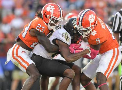 Oct 7, 2023; Clemson, South Carolina, USA; Clemson Tigers cornerback Toriano Pride Jr. (23) and safety R.J. Mickens (9) tackle Wake Forest Demon Deacons defensive back Justin Simpkins (80) during the fourth quarter at Memorial Stadium. Mandatory Credit: Ken Ruinard-USA TODAY Sports