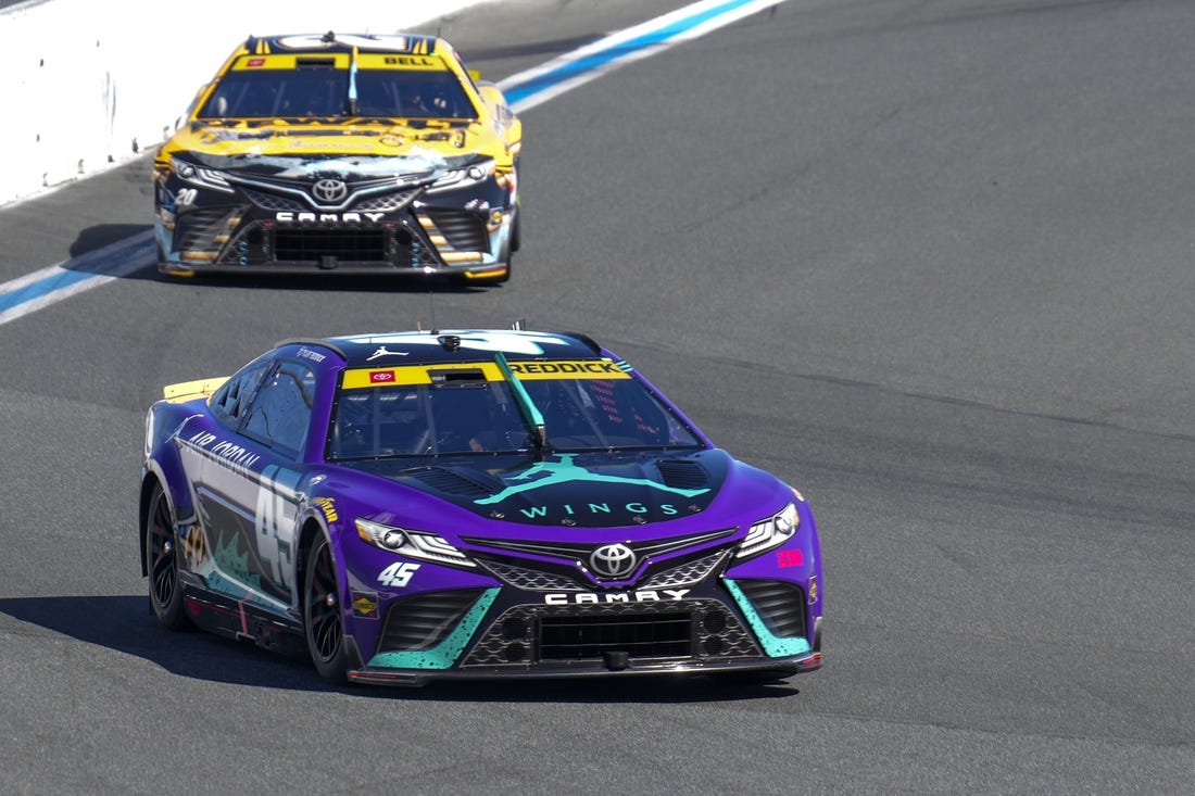 Oct 8, 2023; Concord, North Carolina, USA;  NASCAR Cup Series driver Tyler Reddick (45) leads driver Christopher Bell (20) out of turn eight during the Bank of America Roval 400 at Charlotte Motor Speedway Road Course. Mandatory Credit: Jim Dedmon-USA TODAY Sports