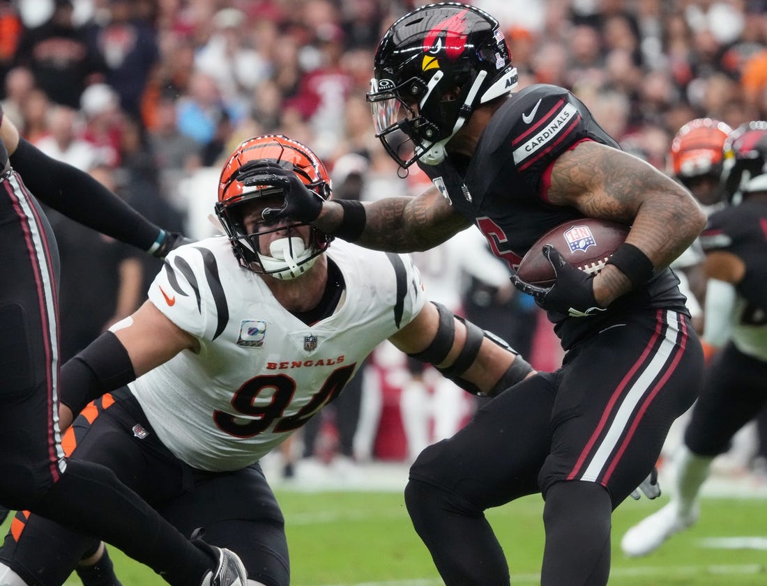 Oct 8, 2023; Glendale, Arizona, United States; Arizona Cardinals running back James Conner (6) stiff arms Cincinnati Bengals defensive end Sam Hubbard (94) at State Farm Stadium. Mandatory Credit: Joe Rondone-USA TODAY Sports