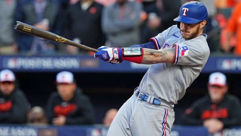 Oct 8, 2023; Baltimore, Maryland, USA; Texas Rangers catcher Jonah Heim (28) hits an RBI single during the second inning against the Baltimore Orioles during game two of the ALDS for the 2023 MLB playoffs at Oriole Park at Camden Yards. Mandatory Credit: Mitch Stringer-USA TODAY Sports