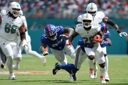 Miami Dolphins running back De'Von Achane (28) breaks free for a gain as New York Giants safety Isaiah Simmons (19) closes in on the play during the first half of an NFL game at Hard Rock Stadium in Miami Gardens, October 8, 2023.