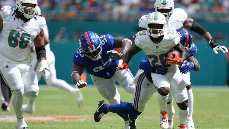 Miami Dolphins running back De'Von Achane (28) breaks free for a gain as New York Giants safety Isaiah Simmons (19) closes in on the play during the first half of an NFL game at Hard Rock Stadium in Miami Gardens, October 8, 2023.