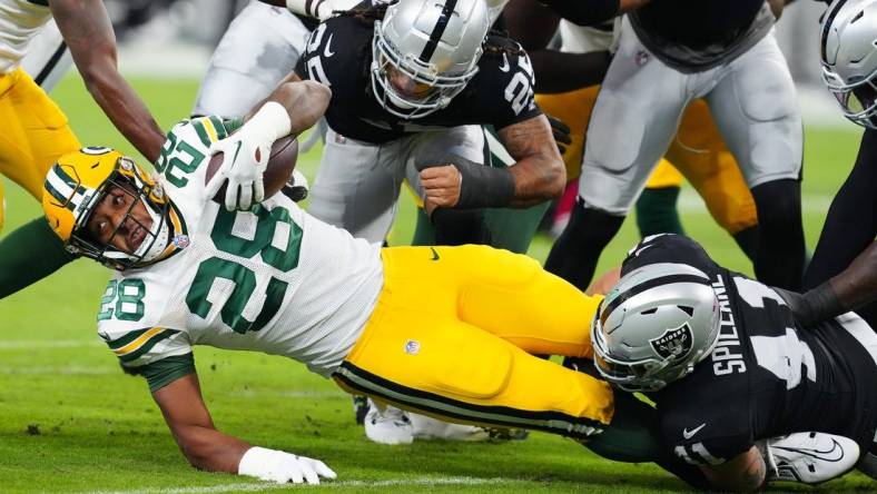 Oct 9, 2023; Paradise, Nevada, USA; Green Bay Packers running back AJ Dillon (28) is tackled by Las Vegas Raiders linebacker Robert Spillane (41) during the first quarter at Allegiant Stadium. Mandatory Credit: Stephen R. Sylvanie-USA TODAY Sports