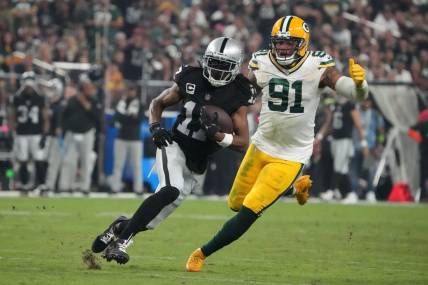Oct 9, 2023; Paradise, Nevada, USA; Las Vegas Raiders wide receiver Davante Adams (17) is pursued by Green Bay Packers linebacker Preston Smith (91) in the second half at Allegiant Stadium. Mandatory Credit: Kirby Lee-USA TODAY Sports