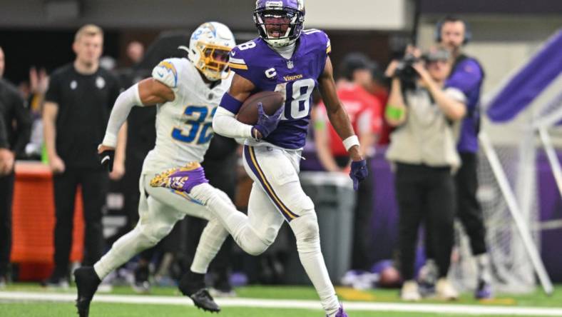 Sep 24, 2023; Minneapolis, Minnesota, USA; Minnesota Vikings wide receiver Justin Jefferson (18) scores on a touchdown pass as Los Angeles Chargers safety Alohi Gilman (32) chases from behind during the fourth quarter at U.S. Bank Stadium. Mandatory Credit: Jeffrey Becker-USA TODAY Sports