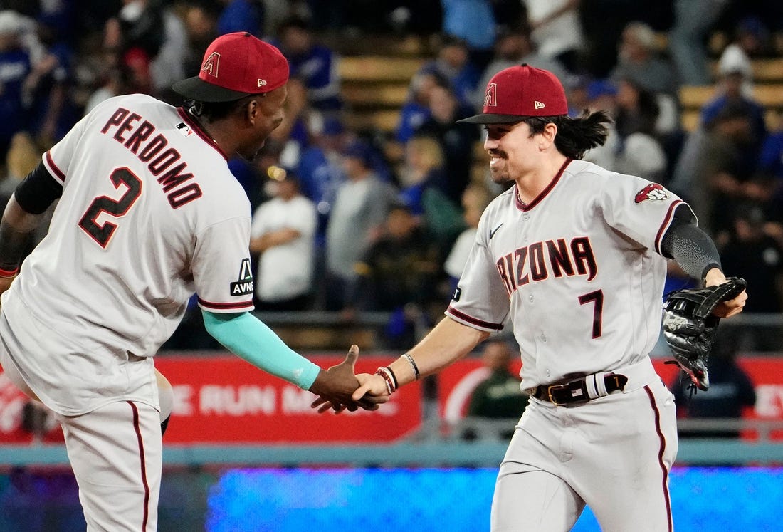 Arizona Diamondbacks shortstop Geraldo Perdomo (2) and Arizona Diamondbacks right fielder Corbin Carroll (7) celebrate their 4-2 win over the Los Angeles Dodgers during Game 2 of the NLDS at Dodger Stadium in Los Angeles on Oct. 9, 2023.