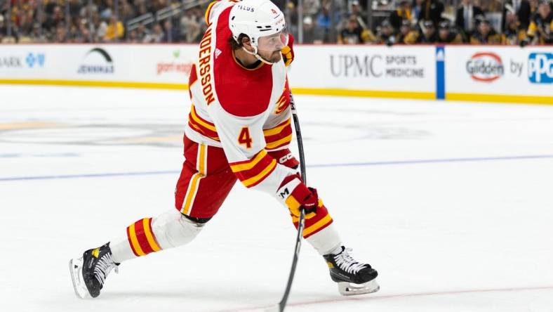 Oct 14, 2023; Pittsburgh, Pennsylvania, USA; Calgary Flames defenseman Rasmus Andersson (4) takes a slapshot against the Pittsburgh Penguins during the second period at PPG Paints Arena. Mandatory Credit: Scott Galvin-USA TODAY Sports