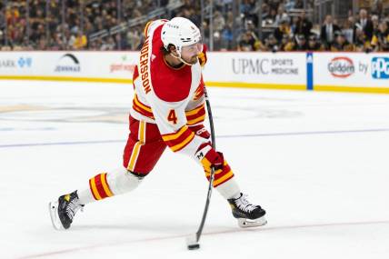 Oct 14, 2023; Pittsburgh, Pennsylvania, USA; Calgary Flames defenseman Rasmus Andersson (4) takes a slapshot against the Pittsburgh Penguins during the second period at PPG Paints Arena. Mandatory Credit: Scott Galvin-USA TODAY Sports